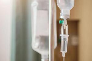 Close up medical intravenous IV drip in hospital background photo