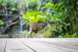 Empty wood table top with blur green tropical garden background for product display photo