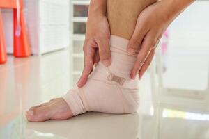 Man with ankle sprain elastic bandage for ankle injury and feeling pain photo