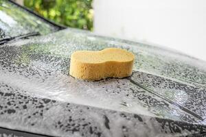 coche limpieza y Lavado con amarillo esponja y espuma jabón foto