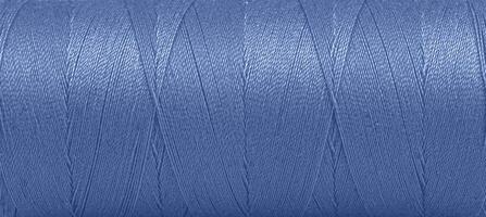 Texture of threads in a spool of blue color on a white background photo