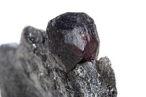 Macro mineral stone garnet  in the rock on a white background photo