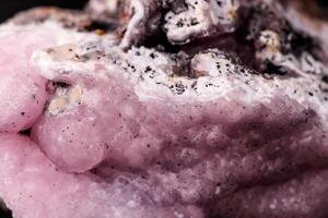 Macro pink Smithsonite mineral stone on microcline on black background photo