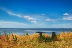 Glade with a bench with a beautiful view of the sea and clouds photo