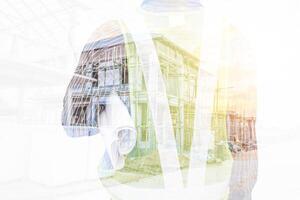 Double exposure image of professional engineer in protective helmet and blueprints paper at building construction site photo