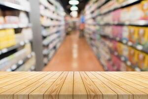 Empty wood table top with supermarket blurred background for product display photo