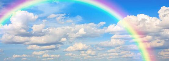 Beautiful rainbow with clouds and blue sky photo