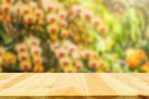 Empty wood table top with blur orchid garden background for product display photo