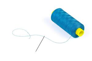 Macro skein of blue thread with a needle on a white background photo