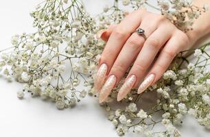 Hand of a young woman with white pearl  manicure photo