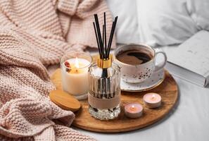 Bamboo sticks in bottle with scented candles and cup of coffee photo