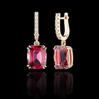 beautiful gold earrings with tourmaline and diamonds on a black background photo