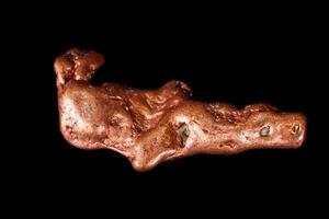 Macro mineral stone of a copper nugget on a microcline on a black background photo