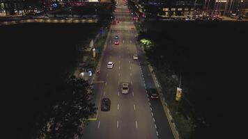 nacht verkeer beweging Bij de centrum van groot stad, antenne stedelijk visie. schot. antenne visie van nacht weg met in beweging auto's en mooi gebouwen. video