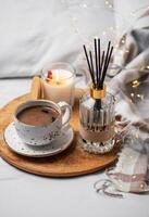 Bamboo sticks in bottle with scented candles and cup of coffee photo