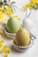 Colorful easter eggs  and mimosa flowers on concrete background photo