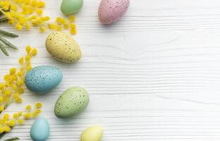 Colorful easter eggs  and mimosa flowers on wooden table. photo