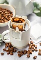 Drip coffee bag with ground coffee in  cup photo