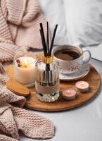 Bamboo sticks in bottle with scented candles and cup of coffee photo