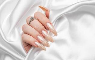 Hand of a young woman with white pearl  manicure photo