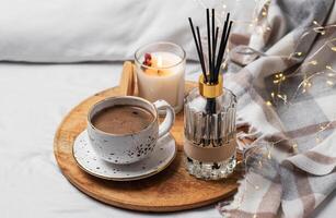 Bamboo sticks in bottle with scented candles and cup of coffee photo