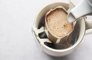 Drip coffee bag with ground coffee in  cup photo