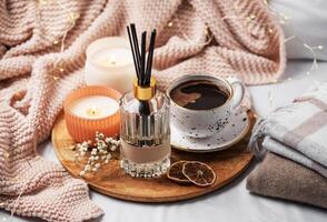 Bamboo sticks in bottle with scented candles and cup of coffee photo
