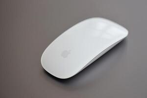 KYIV, UKRAINE - NOVEMBER 27, 2023 Apple Magic Mouse 3rd generation lies with grey MacBook 2021 photo