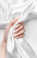 Hand of a young woman with white pearl  manicure photo