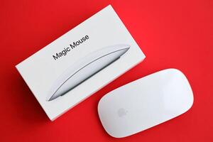 KYIV, UKRAINE - NOVEMBER 27, 2023 Apple Magic Mouse 3rd generation lies on bright colored background photo