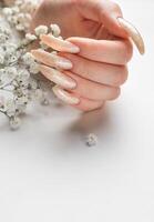 The nails are covered with pearl gel polish on white background photo