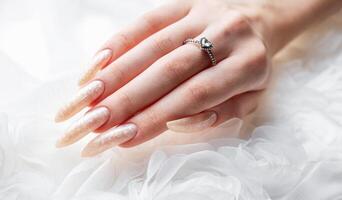 Hand of a young woman with white pearl  manicure photo