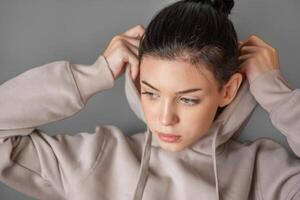 Pensive thoughtful young girl wearing sweatshirt with hood photo