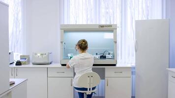 giovane femmina dietologo analisi cibo campioni nel laboratorio. femmina ricercatore Lavorando su un' computer nel un' laboratorio. professionale femmina scienziato è l'esame medico campioni indietro Visualizza video