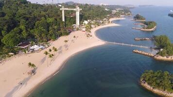 costa de el pequeño isla cerca el ecuador línea con hermoso bosque a lo largo el apuntalar y azul agua. disparo. marina de un pequeño hermosa isla en el mar con palma arboles y rocas video