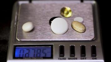 Electronic scales with tablet on black background. Laboratory scales. Pills and medication health, close up. Gray pills on electronic scales video