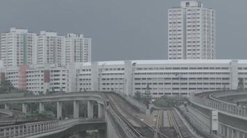 modern tunnelbana tåg på en järnväg i sinapore på en stad byggnader bakgrund. skott. singapore massa snabb tåg mrt resor på de Spår. video