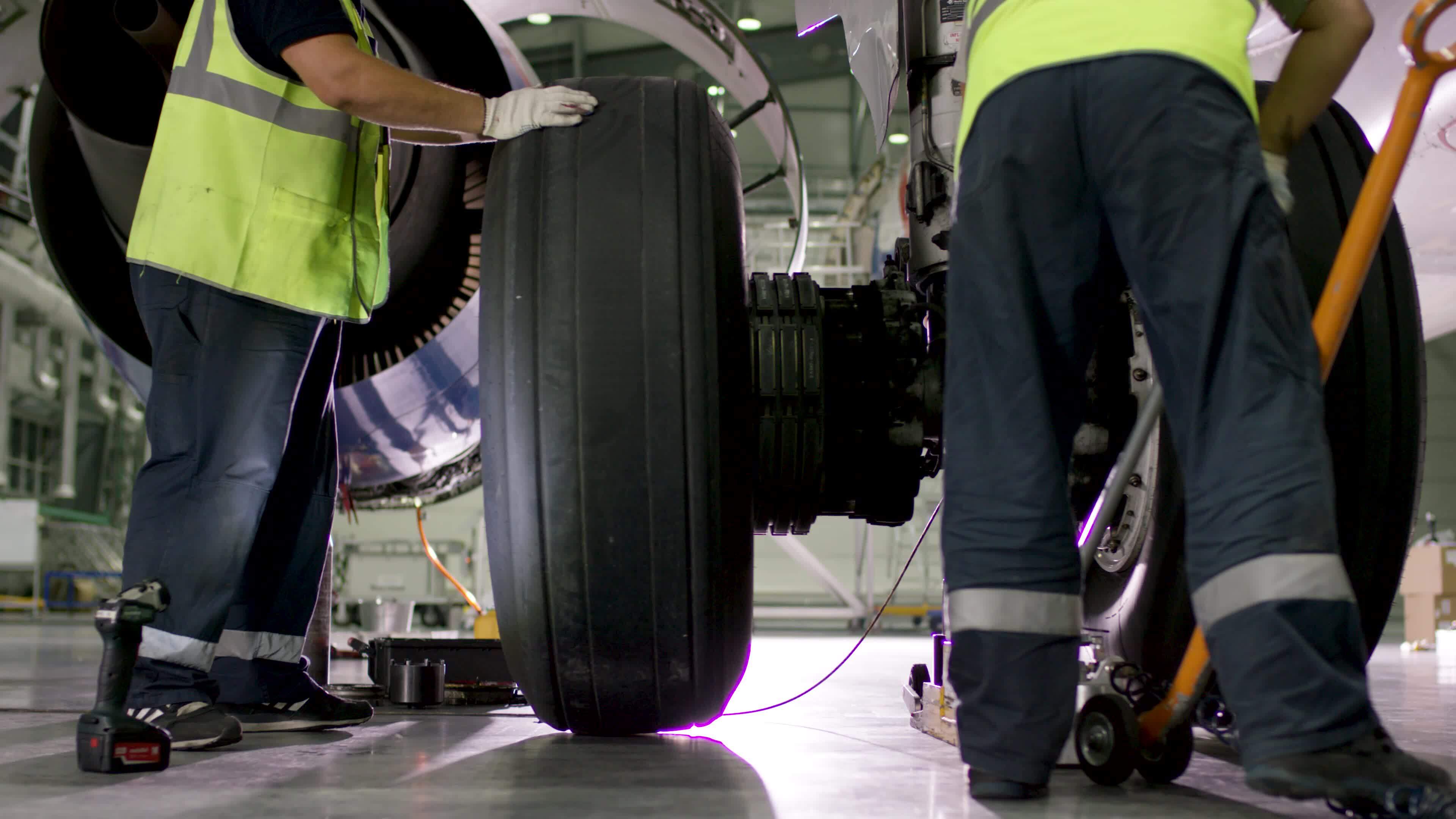 Airport worker checking chassis. Engine and chassis of the passenger