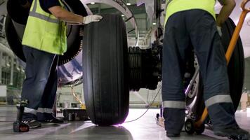 aeropuerto trabajador comprobación chasis. motor y chasis de el pasajero avión debajo pesado mantenimiento. ingeniero cheques el aeronave chasis y motor. video