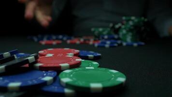 Mens het werpen poker chips Aan zwart achtergrond. poker chips multi kleur met een zwart achtergrond. detailopname van poker chips in stapels Aan groen voelde kaart tafel oppervlakte in langzaam beweging video