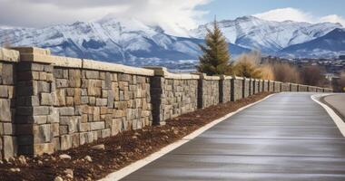 ai generado encantador ruta - un la carretera afilado con un Roca muro, revelando un barrio conjunto en contra Nevado montañas y un gris cielo foto