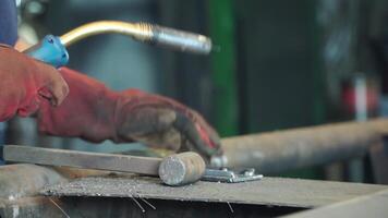 trabajador con protector máscara soldadura metal. un hombre soldaduras un metal con un soldadura máquina. soldador es trabajando a el fábrica y soldadura un metal construcción. soldadores trabajando a el fábrica hecho metal video