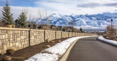 AI generated Charming Commute - A Road Flanked by a Stone Brick Wall, Revealing a Neighborhood with Mountain Views and a Cloudy Sky photo