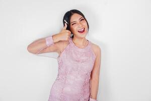 atractivo joven asiático mujer en rosado vestir es gesticulando pulgares arriba foto