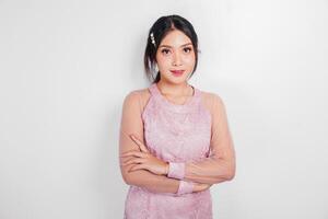 An attractive Asian woman wearing pink dress is smiling to the camera, isolated by white background. photo