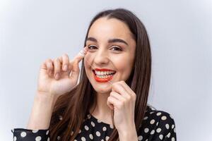 mujer aplicando rojo lápiz labial con un alegre expresión. un mujer poniendo en un rojo lápiz labial con un sonrisa en su cara foto