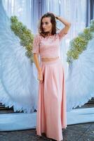 A Woman with Graceful Wings. A woman standing in front of an angel wings backdrop photo