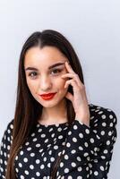 Fashionable Woman with Long Hair in Polka Dot Top. A woman with long hair wearing a polka dot top photo