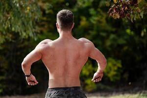 hombre disfrutando el libertad de corriendo mediante un hermosa campo. un hombre con No camisa en corriendo en un campo foto