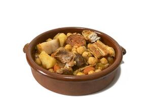 A clay bowl with an Andalusian chickpea stew, isolated on a white background, close-up. Spanish food concept. photo